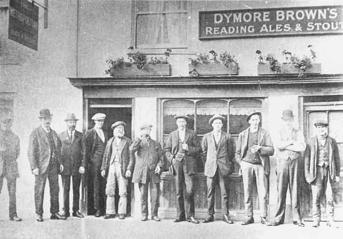 About a dozen men in hats outside building