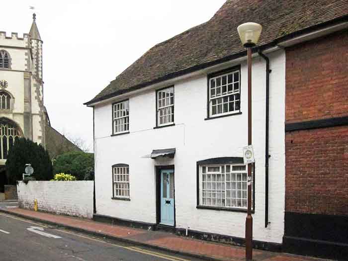 white pub with All Saints church behind